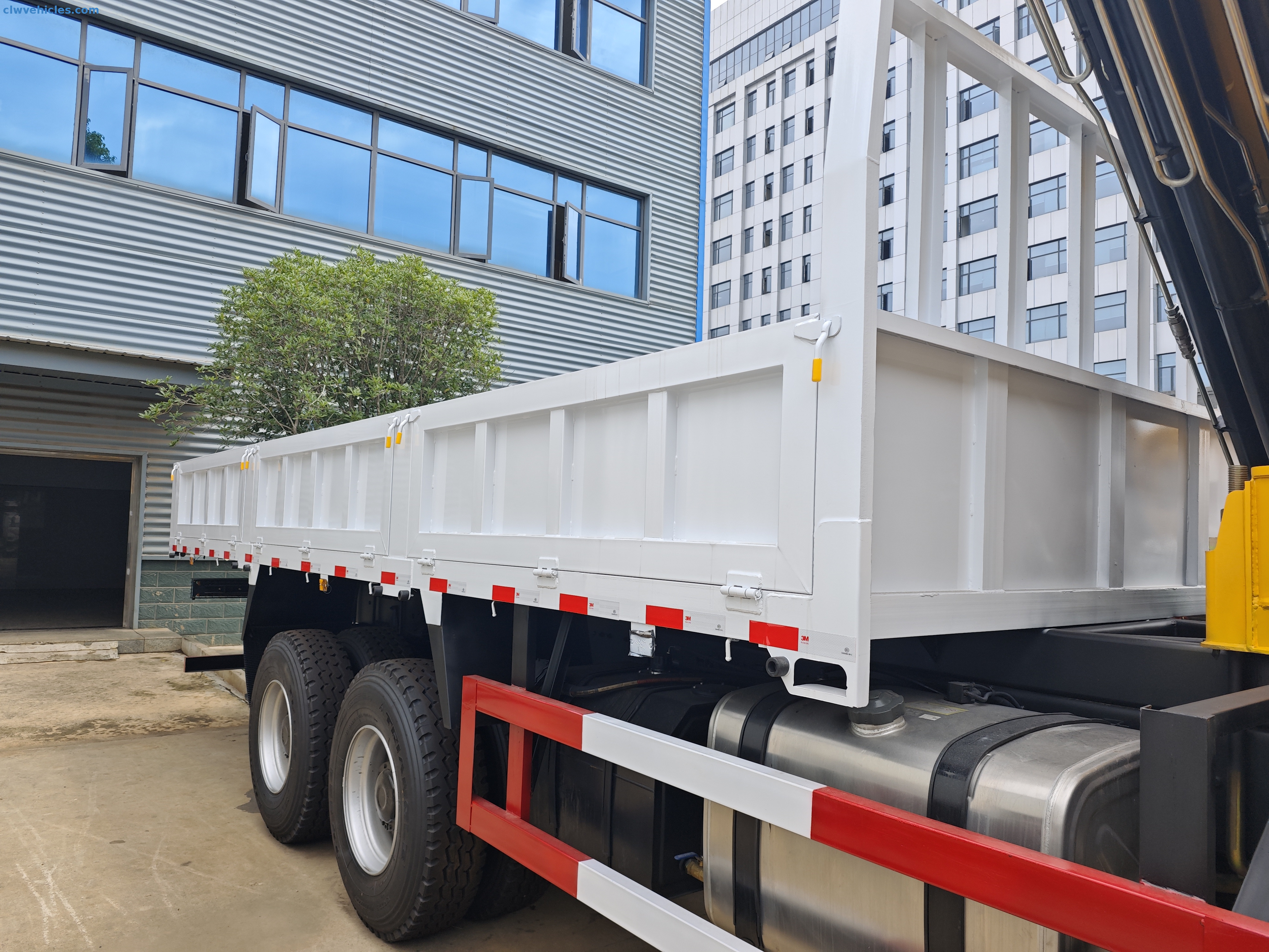 Rear view of Shacman cargo crane truck with large cargo bed and stabilizers