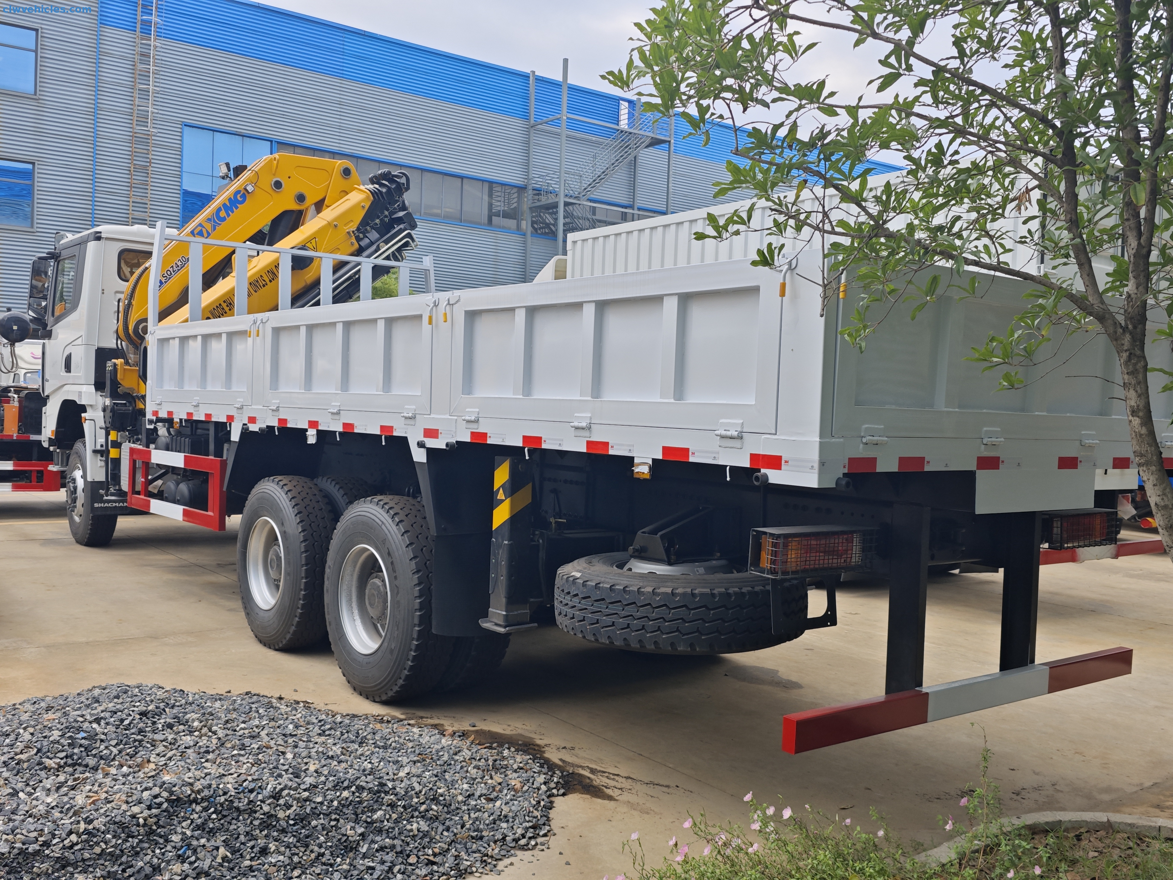 Shacman 6x6 Cargo Truck with Knuckle Boom Crane lifting heavy materials on a construction site