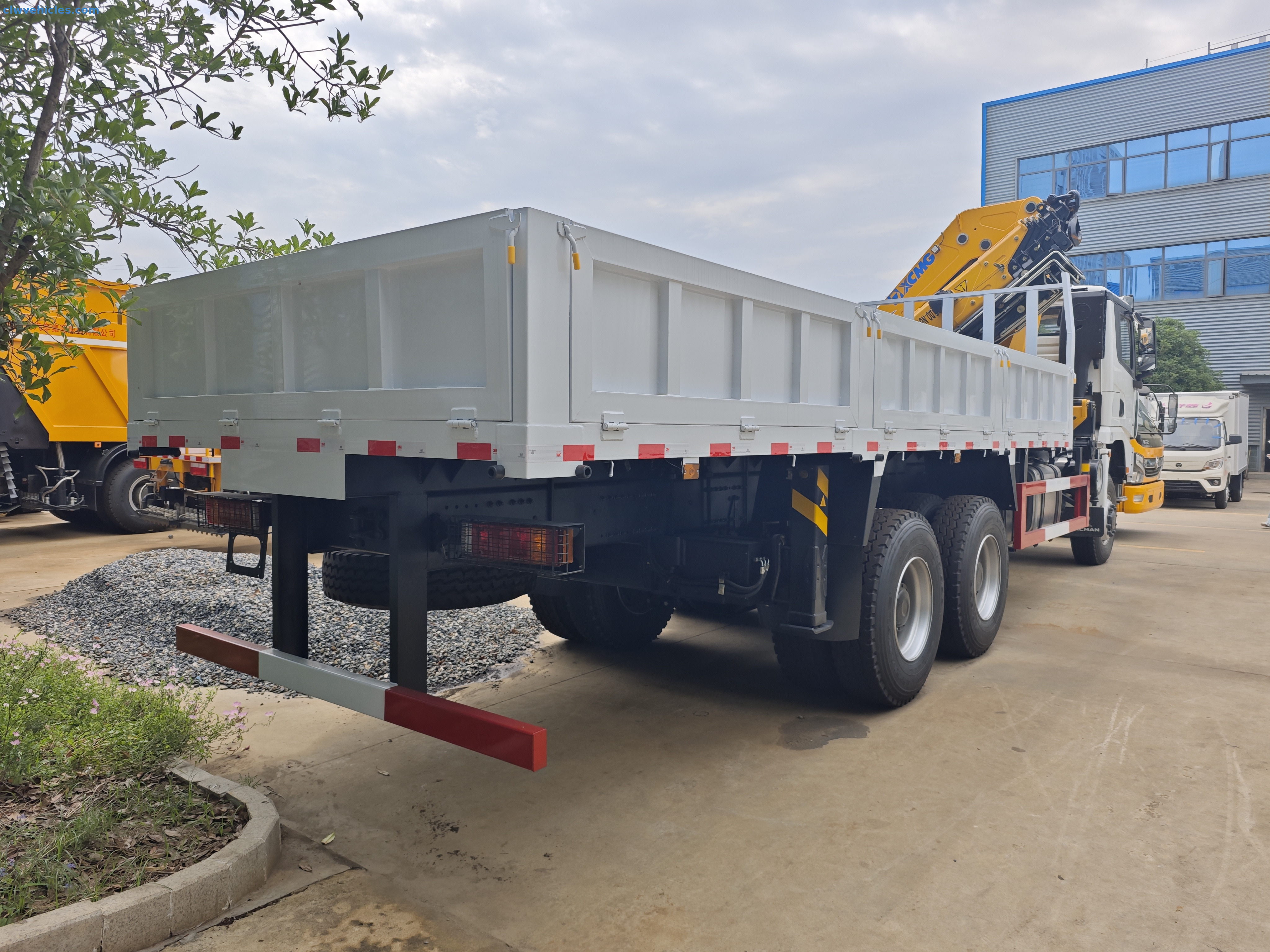 Off-road Shacman 6x6 knuckle boom truck operating in a mining field